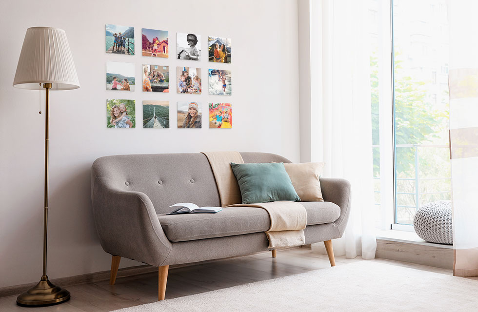 A set of twelve Snapfish Photo Tiles featuring family photos is displayed on a wall above a grey sofa