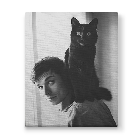 black and white photo with man and a pet cat on his shoulder 
