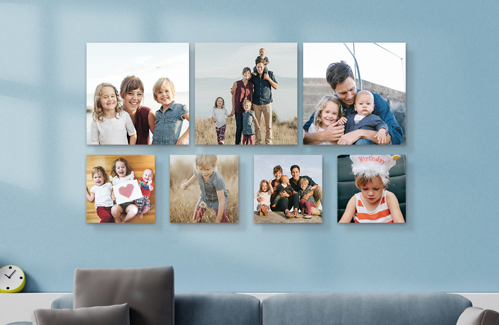 A set of seven Snapfish Photo Tiles featuring family photos is displayed on light blue wall above a sofa