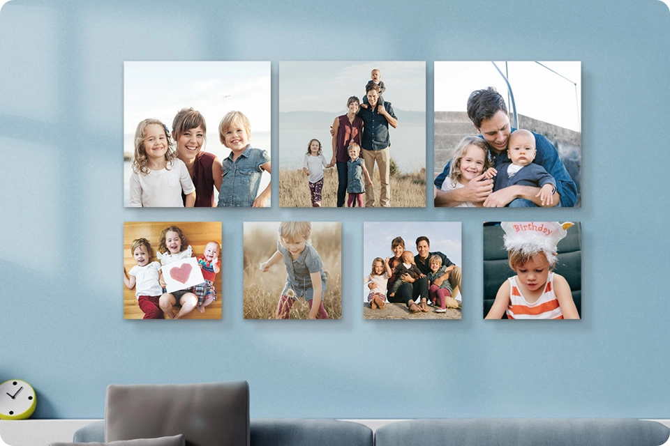 A set of seven Snapfish Photo Tiles featuring family photos is displayed on light blue wall above a sofa