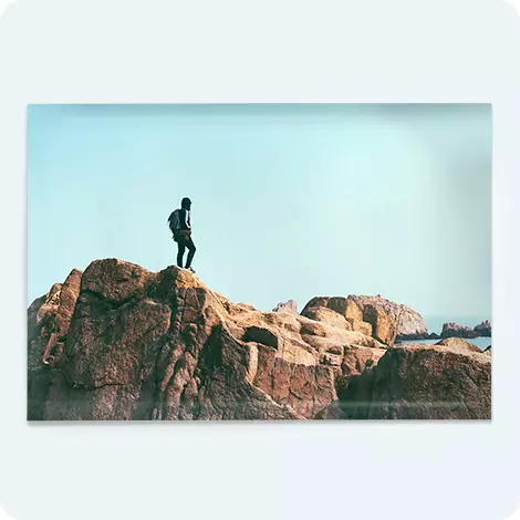 Single photo poster showing a lone man standing on top of rocky landscape. 